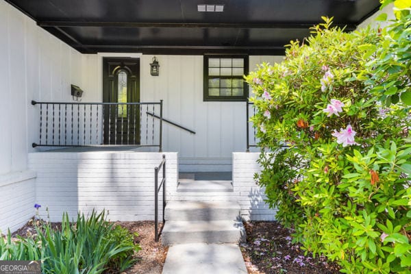 doorway to property with board and batten siding and a porch