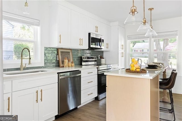 2086 Harold Ave SE, Smyrna, GA 30080 - kitchen with stainless steel appliances, a sink, light countertops, a center island, and decorative backsplash