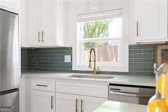 2086 Harold Ave SE, Smyrna, GA 30080 - kitchen with stainless steel appliances, a sink, white cabinetry, light countertops, and backsplash