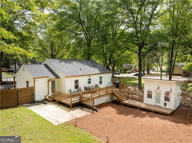 2086 Harold Ave SE, Smyrna, GA 30080 - back of house with a deck, roof with shingles, board and batten siding, view of scattered trees, and a patio