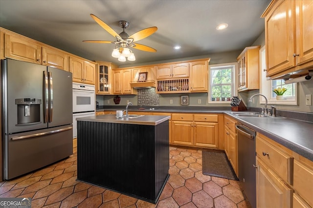kitchen featuring stainless steel appliances, a sink, dark countertops, recessed lighting, and a ceiling fan