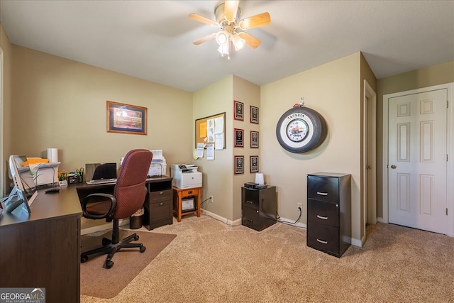 carpeted home office featuring baseboards and ceiling fan