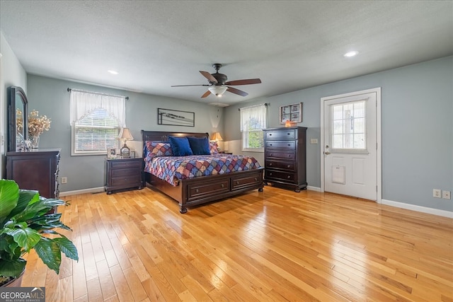 bedroom featuring light wood finished floors, a ceiling fan, baseboards, and recessed lighting