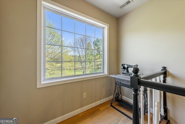 interior space with baseboards, wood finished floors, and visible vents