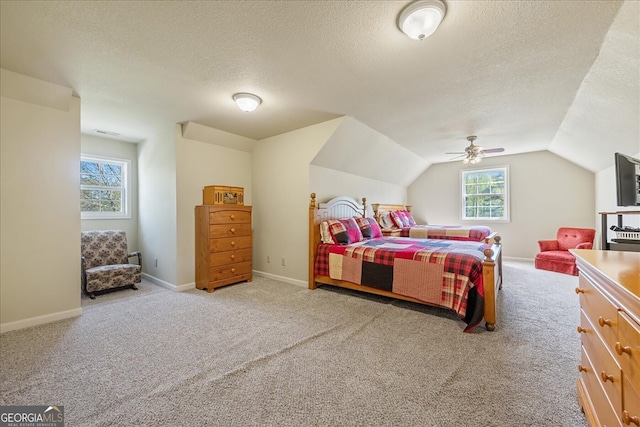 carpeted bedroom with ceiling fan, vaulted ceiling, a textured ceiling, and visible vents