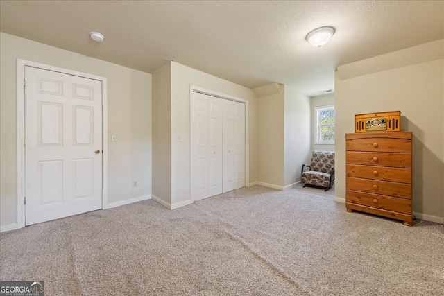 carpeted bedroom with baseboards, a textured ceiling, and a closet