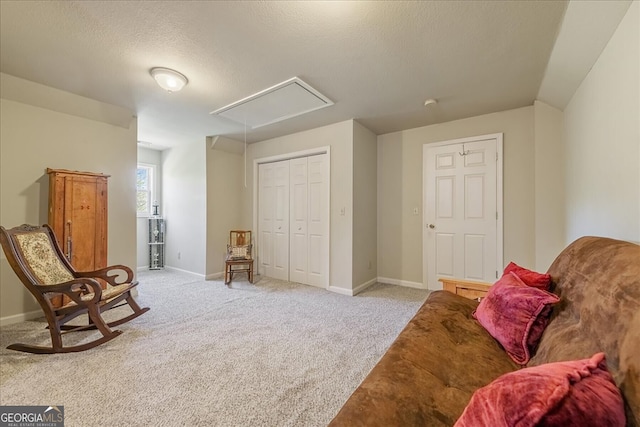 living area with attic access, baseboards, and light colored carpet