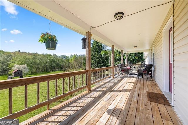 wooden deck with a porch and a yard