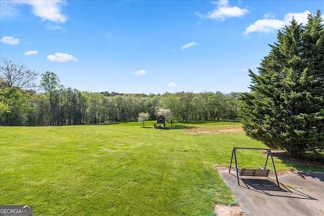 surrounding community featuring a view of trees and a yard