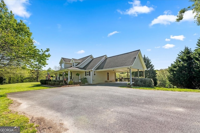 view of front of house with driveway, a porch, a front yard, and a carport