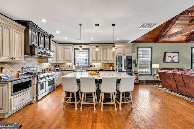 401 Sara Ct, Loganville, GA 30052 - kitchen featuring light stone counters, a kitchen breakfast bar, stainless steel appliances, open floor plan, and visible vents