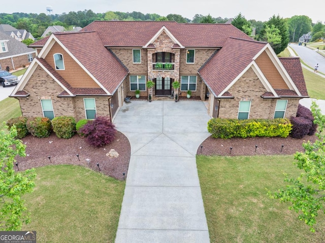401 Sara Ct, Loganville, GA 30052 - view of front of house with a garage, driveway, a front lawn, and a balcony