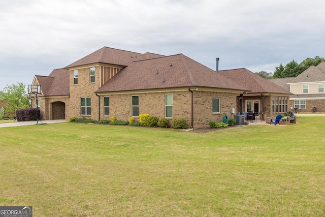 401 Sara Ct, Loganville, GA 30052 - back of house featuring roof with shingles, brick siding, a patio area, a lawn, and driveway