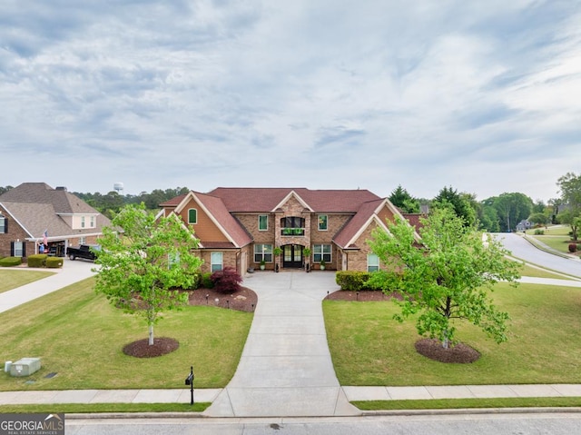 401 Sara Ct, Loganville, GA 30052 - traditional-style house featuring brick siding, a front lawn, driveway, and stone siding