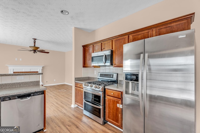 362 Interlake Pass, Mcdonough, GA 30252 - kitchen with stainless steel appliances, a ceiling fan, a textured ceiling, backsplash, and light wood-type flooring