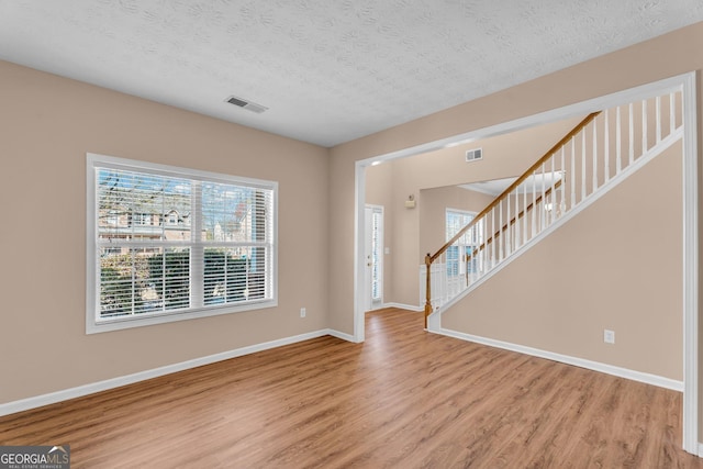 362 Interlake Pass, Mcdonough, GA 30252 - entryway featuring light wood-type flooring, baseboards, a textured ceiling, and stairs