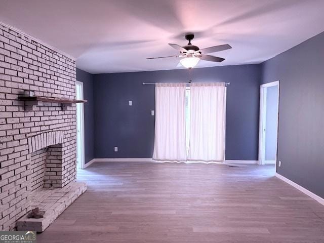 2832 Horseshoe Dr, Macon, GA 31211 - unfurnished living room featuring ceiling fan, baseboards, wood finished floors, and a fireplace