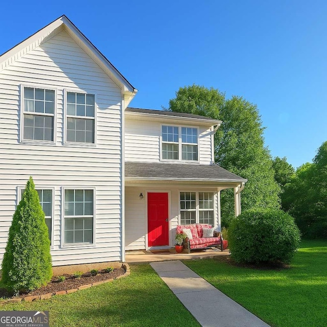 traditional-style home with a porch and a front lawn