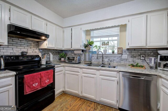 kitchen featuring black electric range oven, a sink, dishwasher, white cabinets, and under cabinet range hood