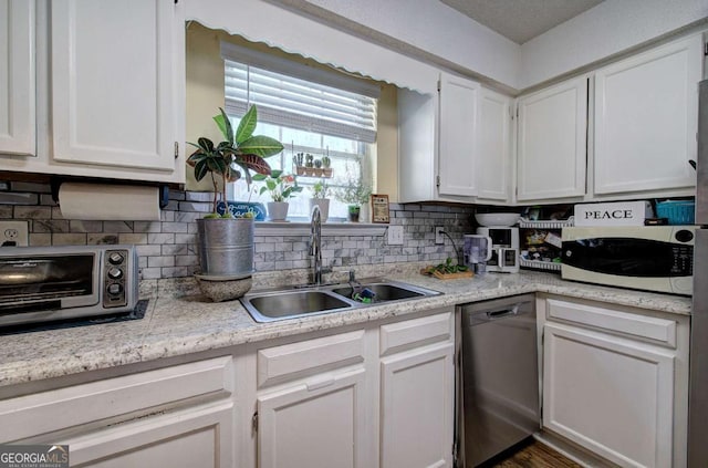 kitchen featuring a sink, decorative backsplash, dishwasher, a toaster, and white cabinetry