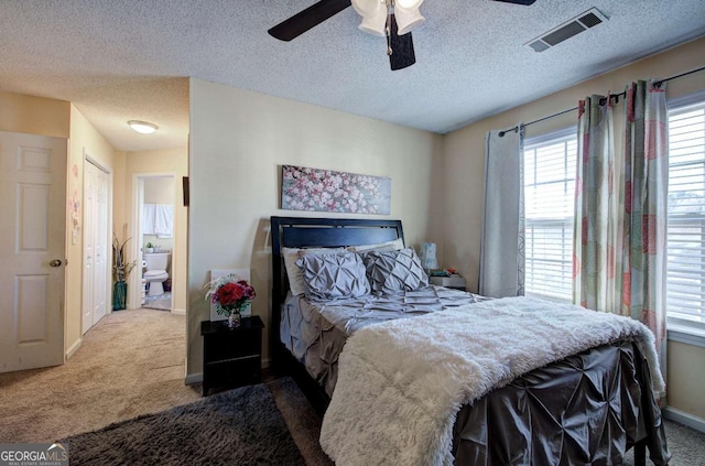 bedroom with baseboards, visible vents, carpet floors, and a textured ceiling