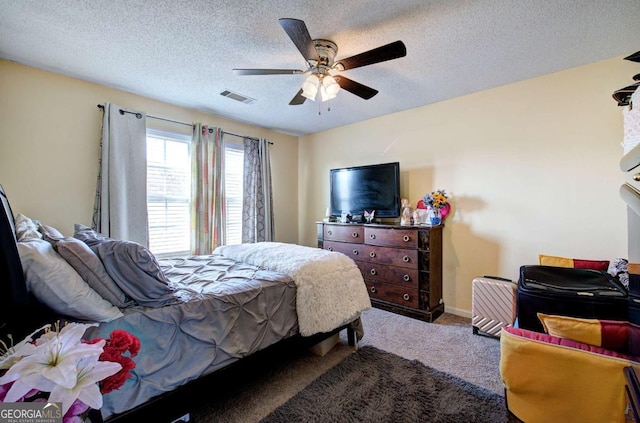 bedroom with a textured ceiling, baseboards, visible vents, a ceiling fan, and carpet floors