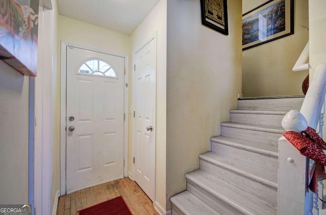 foyer entrance featuring wood finished floors and stairs