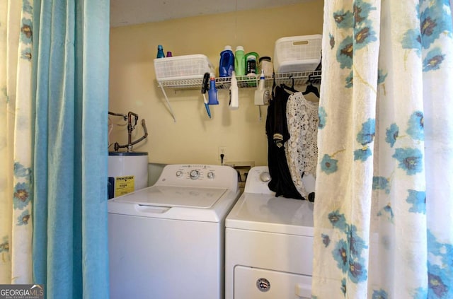 laundry area with water heater, washing machine and clothes dryer, and laundry area