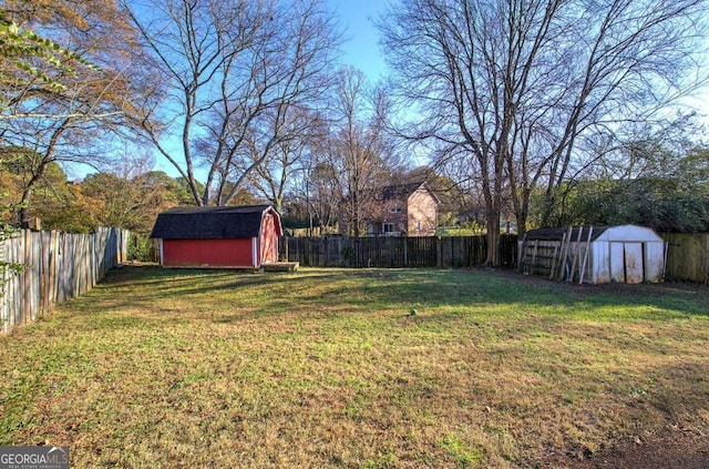 view of yard featuring a fenced backyard, an outdoor structure, and a storage shed