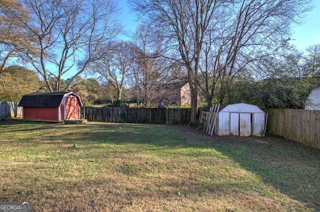 view of yard featuring an outdoor structure, a shed, and a fenced backyard