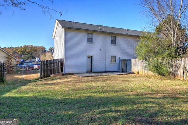 rear view of house with a lawn, a patio area, and a fenced backyard