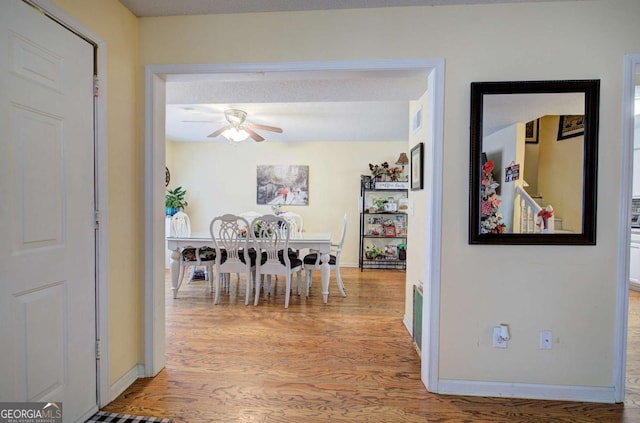 hallway featuring baseboards and wood finished floors