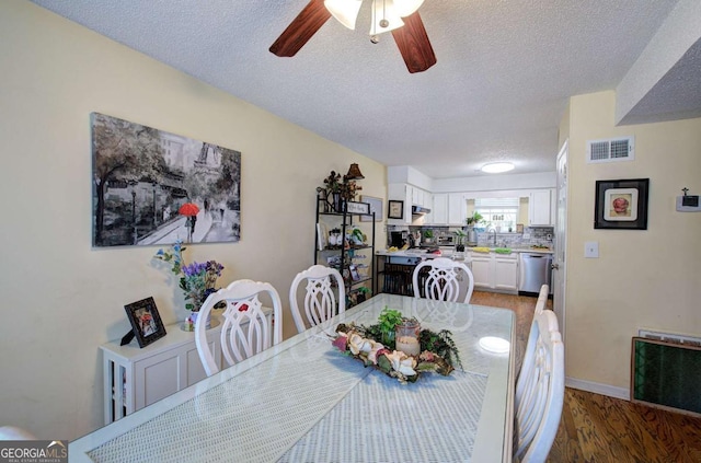 dining space featuring a ceiling fan, visible vents, a textured ceiling, and light wood-style flooring