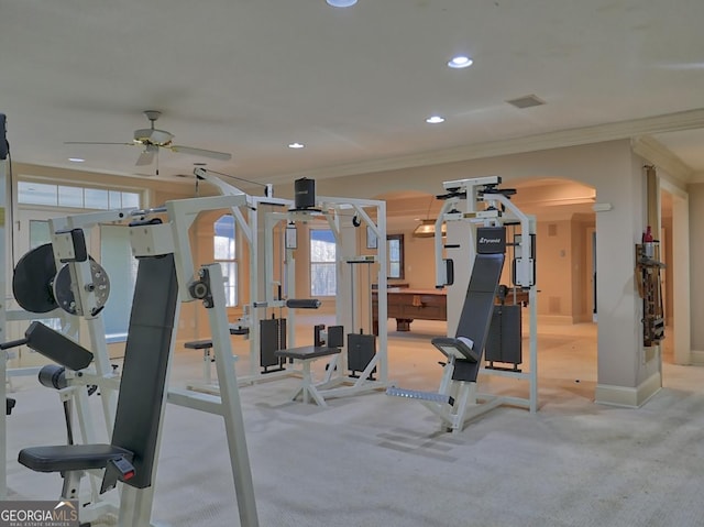 exercise room featuring arched walkways, baseboards, recessed lighting, a ceiling fan, and ornamental molding