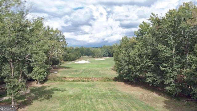 view of community featuring a lawn and view of golf course