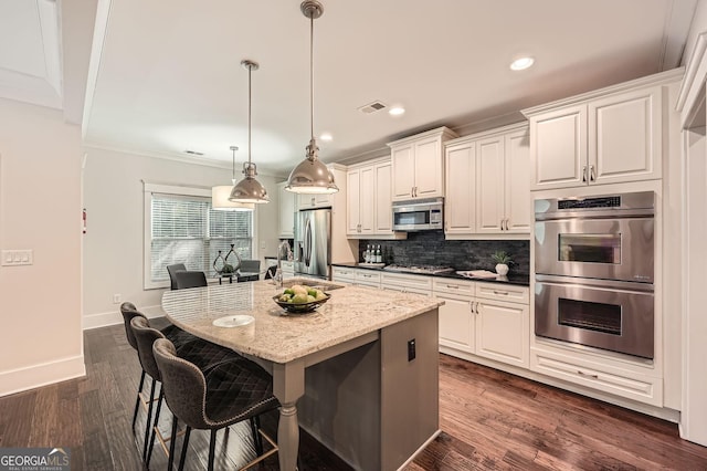 3699 School St, Chamblee, GA 30341 - kitchen with stainless steel appliances, decorative backsplash, a breakfast bar area, a center island with sink, and recessed lighting
