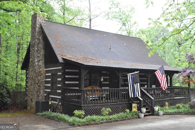 6503 Old Macon Hwy, Rex, GA 30273 - log home with log siding, covered porch, central air condition unit, and a chimney