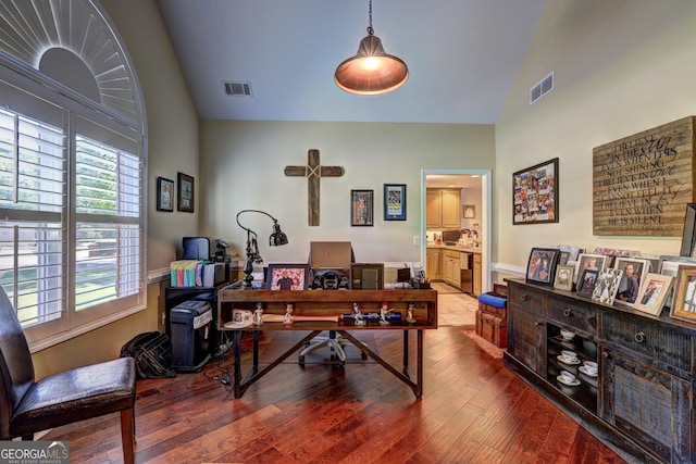 home office featuring wood finished floors, visible vents, high vaulted ceiling, and wainscoting