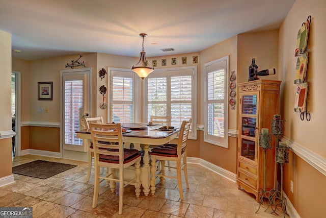 dining area featuring stone tile floors, visible vents, and baseboards