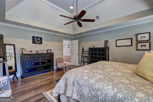 bedroom featuring crown molding, a raised ceiling, ceiling fan, baseboards, and wood finished floors