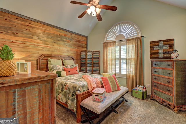 carpeted bedroom with wooden walls, ceiling fan, and high vaulted ceiling