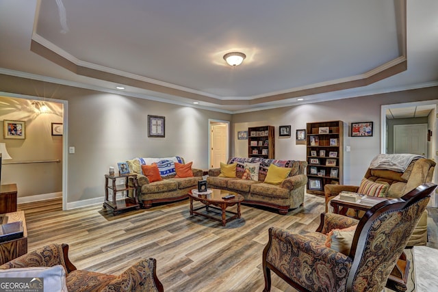 living area featuring recessed lighting, light wood-style floors, a raised ceiling, crown molding, and baseboards