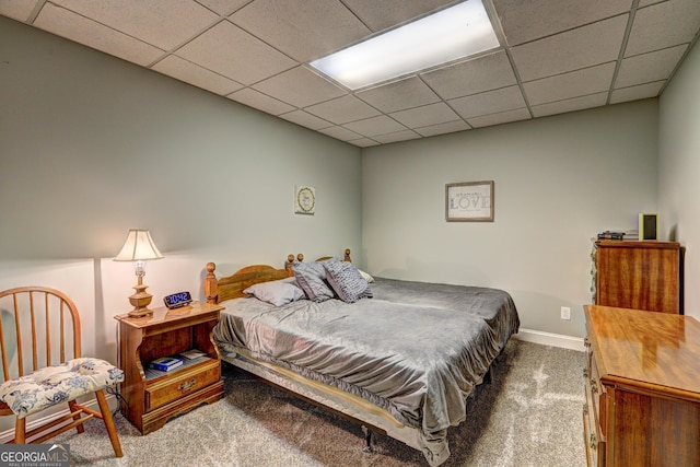 bedroom featuring baseboards, carpet, and a drop ceiling