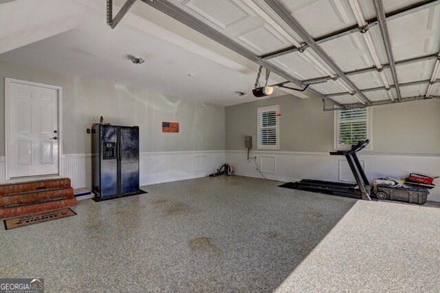 garage with wainscoting and a garage door opener