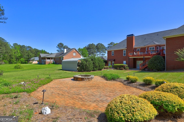 view of yard with stairway, a deck, an outdoor fire pit, and a patio area