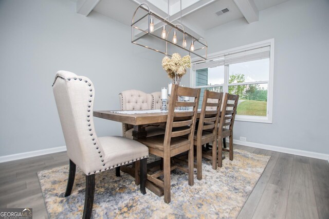 dining room featuring beamed ceiling, wood finished floors, and baseboards