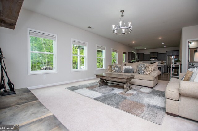 living area with a chandelier, recessed lighting, baseboards, and light carpet