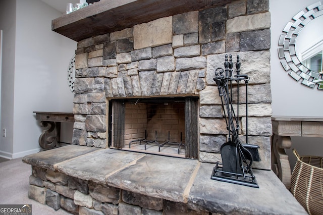 detailed view of a fireplace, baseboards, and carpet