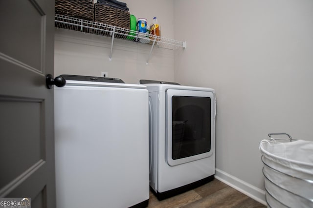 clothes washing area featuring dark wood-type flooring, baseboards, and separate washer and dryer