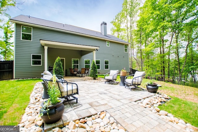 rear view of house featuring a patio and a chimney
